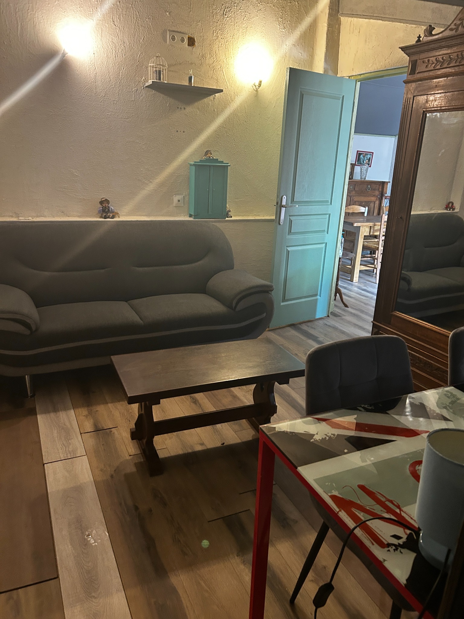 Autre côté de la deuxième chambre avec le canapé, la table basse et l’armoire